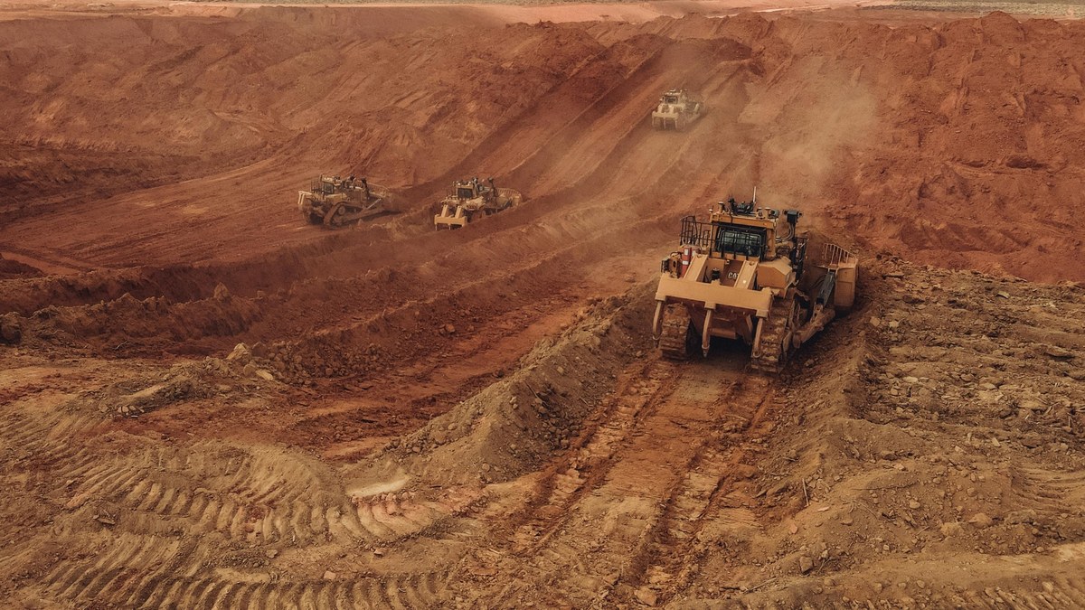 Aerial view of an open-cut gold pit in the Northern Territory with terraced benches and pit-floor water collection — visual cue for the NT mine closure transition under the Mining Management Act 2001
